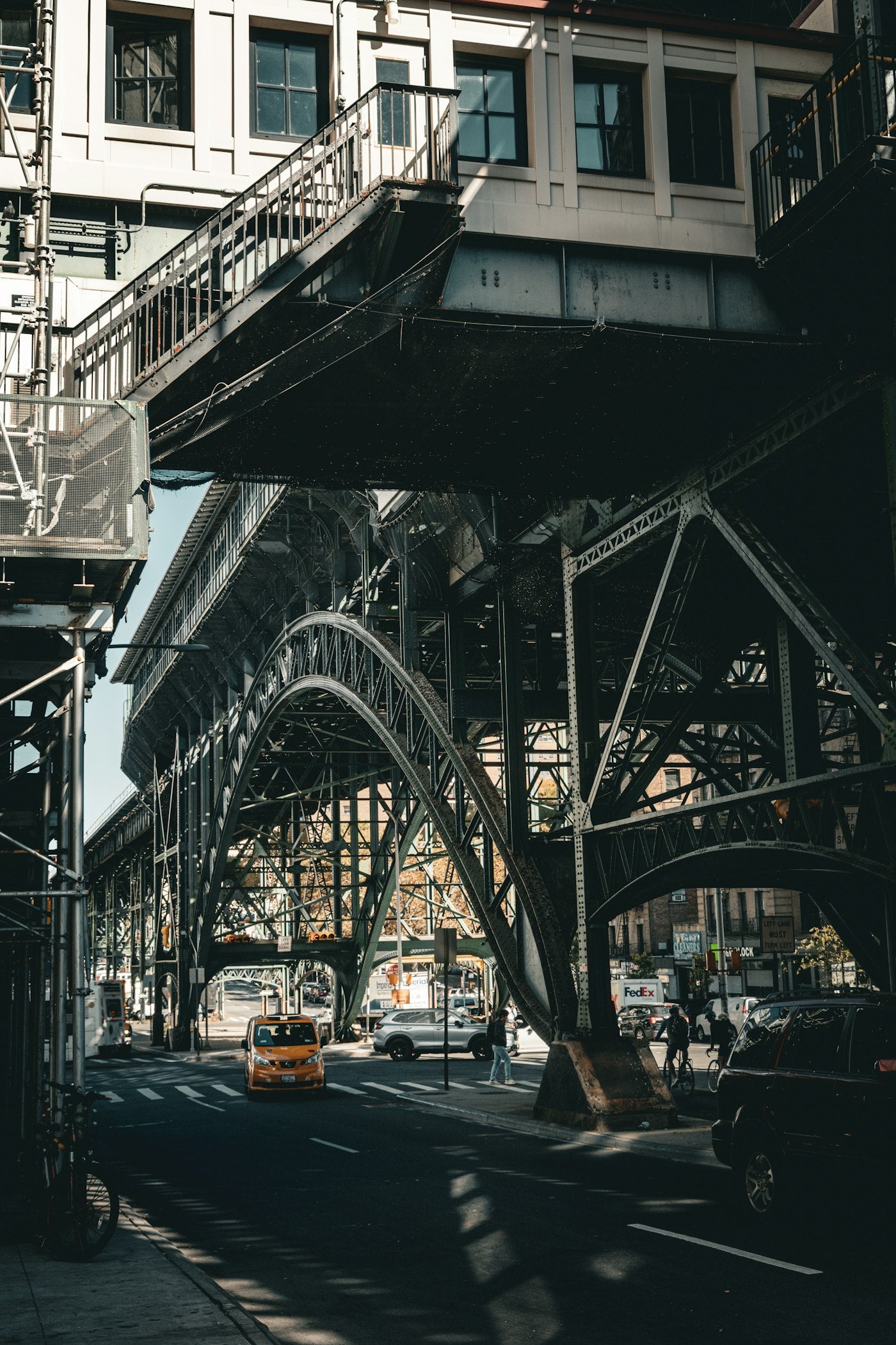 A real New York street beneath dark steel urban infrastructure, photographed by Iuliia Dutchak.